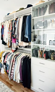 a closet filled with lots of clothes and handbags on top of shelves next to a rug