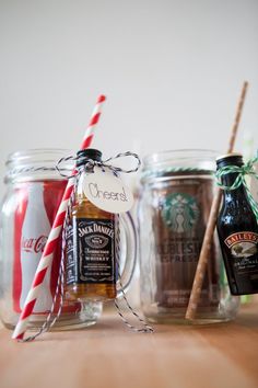 three mason jars filled with different types of drinks and candy canes on top of a wooden table