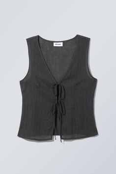 A slim fit vest top crafted from a crisp plain cotton. It has a V-neckline, a double tie front closure, darts at the bust and in the back for added structure and falls at the hips. Cool Pieces Of Clothing, Diy Vest Top, Vest Top Sewing Pattern, Cute Spring Tops, Vest Top Outfits, Grey Top Outfit, Tie Front Vest, Clothes Pieces, Black Vest Top