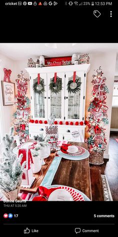 a dining room table decorated for christmas with red and white decorations