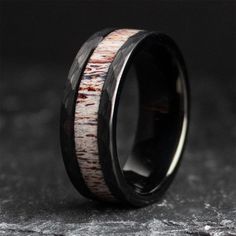 a wedding ring made out of antelope wood and black ceramic