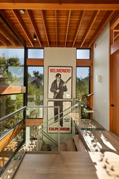 a poster adorns the staircase leading to an upper level bedroom in this modern house