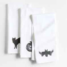 three napkins with black and white designs on them, one has a cat in the middle