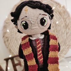 a crocheted doll wearing glasses and a scarf