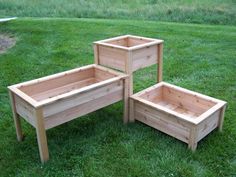 three wooden planters sitting in the grass