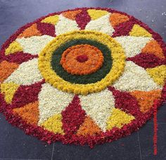 a colorful flower arrangement on the ground in front of a building