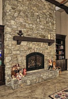 a living room filled with furniture and a fire place in front of a stone fireplace