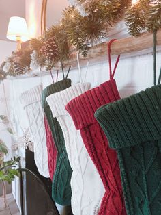 christmas stockings hanging from a mantle in front of a mirror