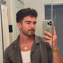 a man taking a selfie in front of a bathroom mirror with his cell phone