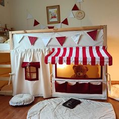 there is a stuffed bear in the bunk bed with red and white stripes on it