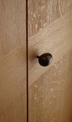 a wooden cabinet with a black handle on it