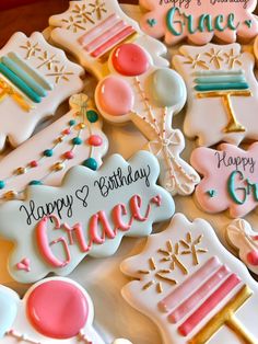 decorated cookies with happy birthday and grace written on the ones in pink, blue, white and gold