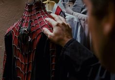 a man is trying to fix his spider - man costume