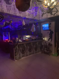 a room filled with lots of halloween decorations and hanging spider webs on the ceiling