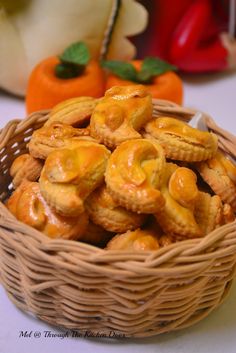 a wicker basket filled with cookies sitting on top of a table next to pumpkins