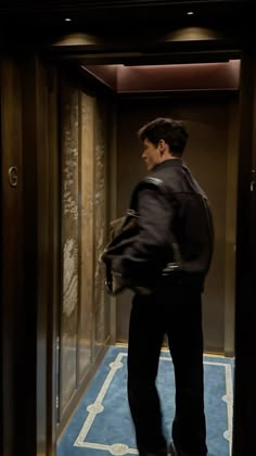 a man is standing in an elevator with his back to the camera and looking at something