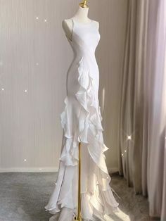 a white dress on a mannequin in front of curtains