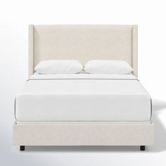 a bed with white linens and pillows on it's headboard is shown