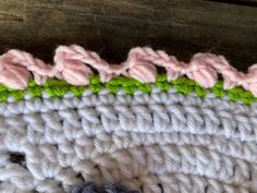 a close up of a crocheted piece of cloth with flowers on the side