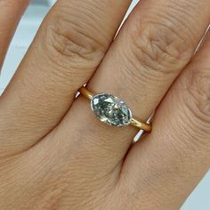 a woman's hand with a ring on it and a diamond in the middle