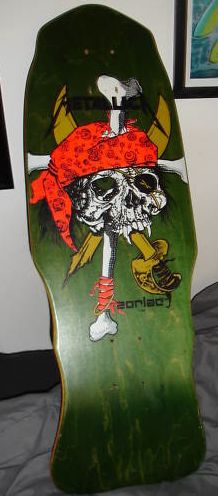 a skateboard with a skull on it sitting on top of a bed next to a wall