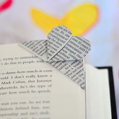 an origami heart shaped bookmark on top of a book