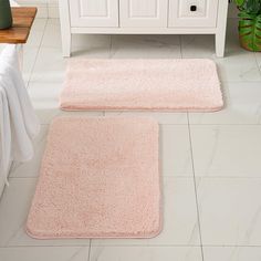 two bath mats on the floor in a bathroom