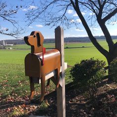 a dog mailbox in the shape of a brown dog on top of a wooden post