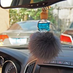 the interior of a car with a fur ball hanging from it's dash board