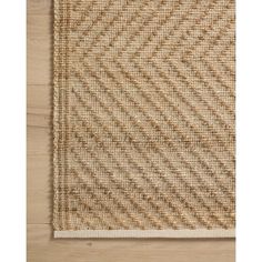 a beige rug on top of a wooden floor