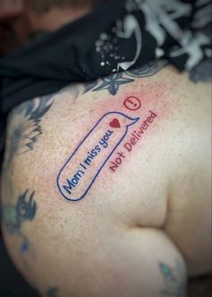 the back of a man's stomach with tattoos on it and words written in blue ink