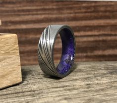 a purple ring sitting on top of a wooden block