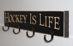 there is a sign that says hockey is life hanging on the wall next to hooks