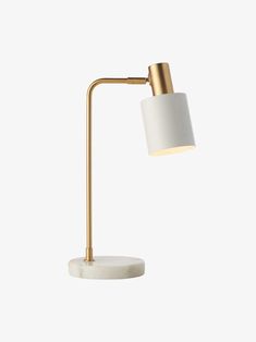 a white and gold desk lamp with a marble base on a white wall behind it