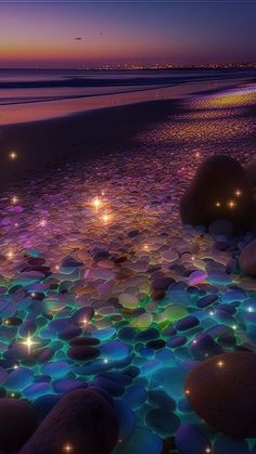 some rocks and lights on the beach at night