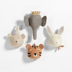 three stuffed animals are hanging on the wall next to an elephant, tiger, and bear head