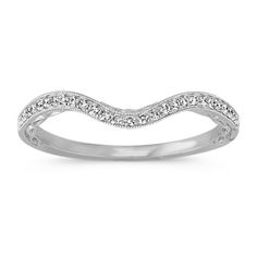 a white gold wedding band with diamonds on the sides and a curved design in the middle