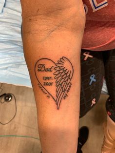 a person with a tattoo on their arm that has a heart and wings in it