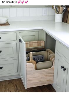 an open drawer in a kitchen next to a counter with utensils and other items