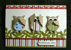 three owls sitting on top of each other in front of a card that says another year older