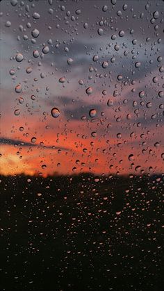 rain drops on the window as the sun sets