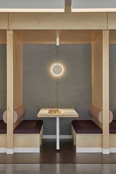 two benches and a table in a room with light fixtures on the wall above them