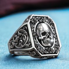 Step into a world of opulence and intrigue with our Royal Vintage Skull Rococo Pattern Signet, crafted from high-quality 925 sterling silver. This exquisite ring features a detailed skull design set against a backdrop of intricate Rococo patterns, embodying a blend of regal elegance and gothic allure. The antique finish adds a touch of vintage charm, making it perfect for those who appreciate unique and sophisticated jewelry. The adjustable band ensures a comfortable fit for any finger size, add Luxury Elegant White Gold Skull Ring, Rococo Pattern, Bold Statement Jewelry, Regal Elegance, Sophisticated Jewelry, Masonic Ring, Vintage Skull