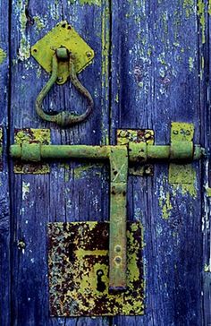 an old blue door with rusted metal latch