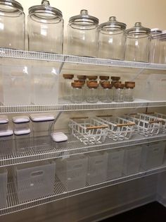 the shelves are filled with clear jars and plastic containers