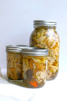 three jars filled with food sitting on top of a table