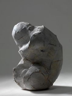 a white sculpture sitting on top of a gray floor next to a black and white wall