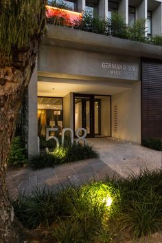 the entrance to a building with plants and lights