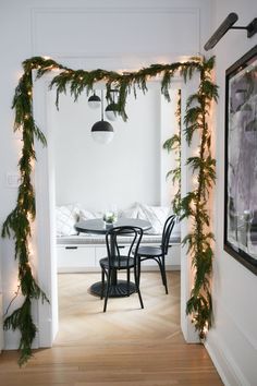 a dining room table with christmas garland on it