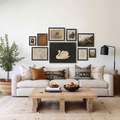 a living room filled with lots of pictures on the wall above a couch and coffee table